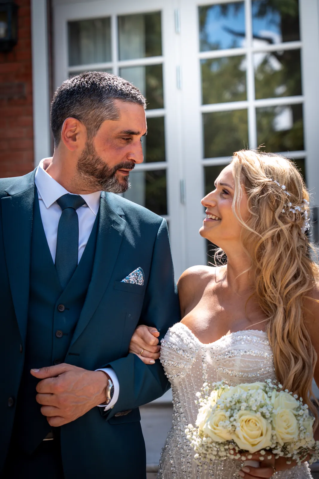Les mariés face à face devant la maison, jour de mariage